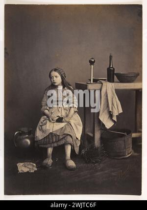 Cosette sitzt am Tisch. Foto von Edmond Bacot (1814-1875), 1862-1863. Paris, Maison de Victor Hugo. 38346-2 sitzend, französischer Schriftsteller, Kind, Illustration, Szene, Romanfigur, kleines Mädchen, Tisch Stockfoto