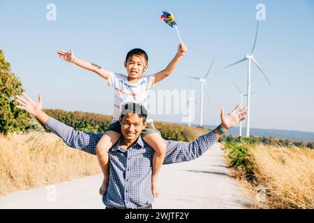Vater hält Tochter mit Windrad Stockfoto