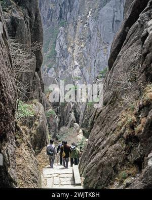 China. Provinz Anhui. Huangshan Mountains. Gruppe chinesischer Männer, die die Stufen des Jade Screen Tower hinabsteigen. Stockfoto