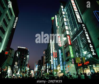 Japan. Tokio. Bezirk Shinjuku. Geschäftige Straßenszene mit hellen Lichtern bei Nacht. Stockfoto