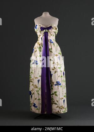 Jeanne Lanvin (1867-1946) und Castillo (Antonio Canovas del Castillo del Rey, dit) (1908-1984). Abendkleid. Marke: Jeanne Lanvin - Castillo. Taffeta auf Kette mit blauen Blumen (rosa) mit Stäben mit Stielen auf weißem Hintergrund des Staron Hauses, lila Satin. Frühjahr-Esté 1957. Galliera, Modemuseum der Stadt Paris. Annies Fifty 1950 50, blau, Kette, feminin, Frau, rosa Blume, Sternenhaus, Muster, Knoten, Abendkleid, Band, lila Satin, bedruckter Taft, Stiel Stockfoto