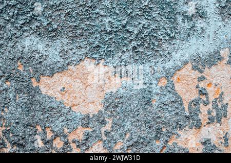 Alte zerrissene, verwitterte, gemalte Hintergrundstruktur der Wand. Schmutzige, abgeschälte Putzwand mit abfallenden Farbflecken. Abstraktes Schleifen unebener Oberfläche mit Stockfoto