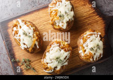 Ganze gebackene Kartoffeln gefüllt mit französischen Zwiebeln und Gruyerekäse in einer Schüssel auf dem Tisch. Horizontale Draufsicht von oben Stockfoto