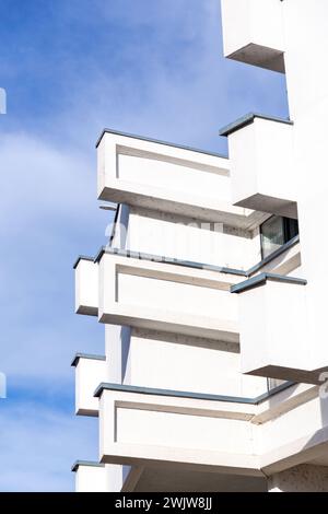 Architektonisches Detail aus einem weißen modernen Betongebäude mit rechteckigen Details vor dem blauen Himmel, modernistisches Architekturfragment. Stockfoto