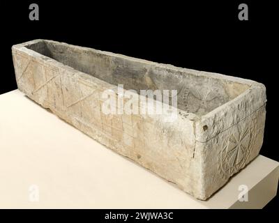 Anonym. Sarkophag-Tank. Geformter Putz. VIII. Jahrhundert. Paris, Carnavalet Museum. Sarkophag-Tank komplett dekoriert. Kopfplatte in einem Krisma, dessen Äste Palmen in zwei kreisförmigen Wolfszähnen sind. Malta Kreuzbasis in einem doppelten schraffierten Kreis. Längstafel rechts in fünf Fächern und von links nach rechts, Kreuz Saint André, zwei Fächer in sechs Dreiecke unterteilt, Schachbrett, schließlich Vogelsilhouette, die von einem kleinen stilisierten Charakter mit rechts einer Palme überragt wird ( ). Linkes Längsblech in fünf Fächern, von links nach rechts, menschliche Silhouette Stockfoto
