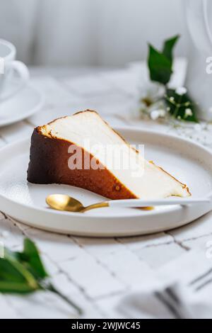 Beliebtes spanisches Dessert namens San Sebastian Käsekuchen. Klassischer baskischer Käsekuchen mit verbranntem Käse. Ein Stück Kuchen auf weißem Hintergrund Stockfoto