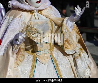 Aristokratische Frau in Maske mit historischem handgefertigtem Kostüm und weißem Handschuh während des Karnevals in Venedig Stockfoto