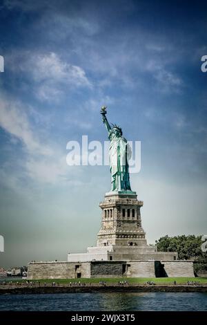 Touristen werden von der Freiheitsstatue auf Liberty Island im Hafen von New York City in den Schatten gestellt. Stockfoto
