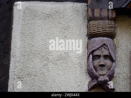 Handgeschnitzte Holzfigur an der Fassade eines Fachwerkhauses in Turckheim, Elsass Frankreich. Stockfoto