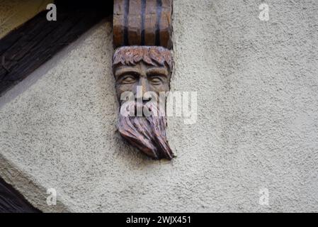 Handgeschnitzte Holzfigur an der Fassade eines Fachwerkhauses in Turckheim, Elsass Frankreich. Stockfoto