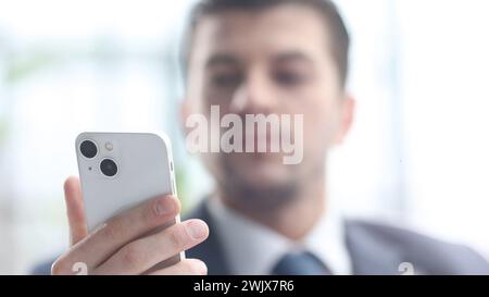 Ein männlicher Geschäftsmann benutzt ein Handy in Nahaufnahme Stockfoto