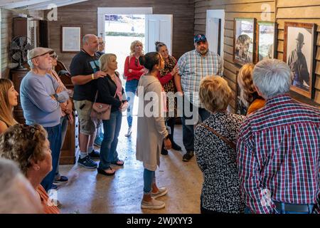 Frau, die eine Tour macht und Fotos vor Jack Daniels Büro in der Jack Daniel Distillery Facility in Lynchburg, Tennessee ansieht Stockfoto