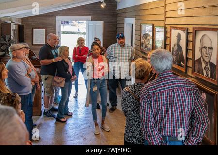 Frau, die eine Tour macht und Fotos vor Jack Daniels Büro in der Jack Daniel Distillery Facility in Lynchburg, Tennessee ansieht Stockfoto