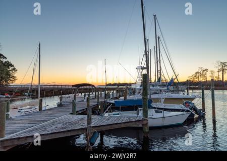 Sonnenuntergang hinter Fischerbooten und Segelbooten im Yachthafen an der Ward Cove vor Rocky Bayou in Niceville, Florida Stockfoto