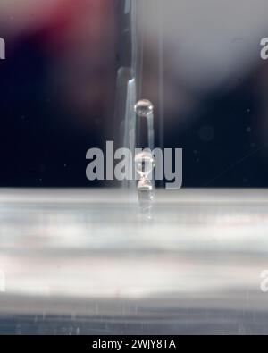 Abstraktes Bild mit farbigen Tropfen verschiedener Formen, unscharfem Hintergrund, Wassertropfenspritzer, Nahfokus, körniger Wasserstruktur Stockfoto