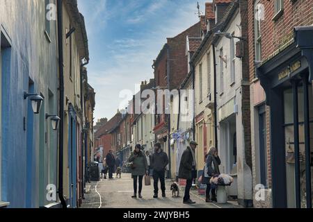 Wells-next-the-Sea, Norfolk, England, Großbritannien - Leute kaufen in der engen Staithe Street, der Hauptstraße der Stadt Stockfoto