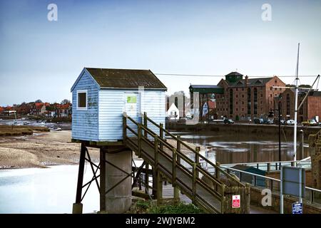 Wells-next-the-Sea, Norfolk, England, UK - Wells Hafen bei Flut. Die blaue Hütte ist die Gezeitenrekorderstation. Stockfoto