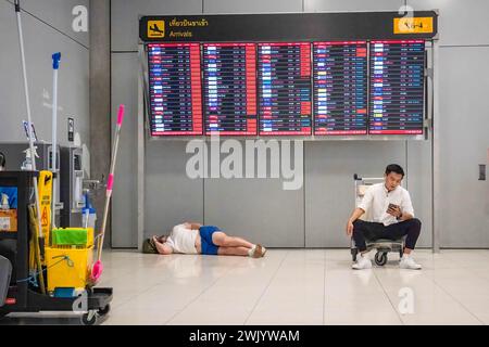 Bangkok, Thailand. Februar 2024. Touristen ruhen sich unter dem Ankunftsflugbrett am Suvarnabhumi, Bangkok International Airport aus. (Credit Image: © Nathalie Jamois/SOPA Images via ZUMA Press Wire) NUR REDAKTIONELLE VERWENDUNG! Nicht für kommerzielle ZWECKE! Stockfoto