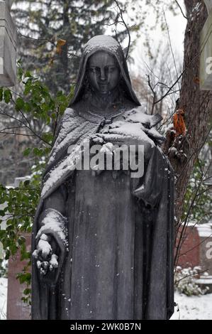 Eine schneebedeckte Skulptur einer weiblichen Figur auf Montreals historischem Friedhof Notre-Dame-des-Neiges, dem größten in Kanada. Stockfoto