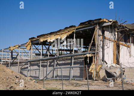 Teilweise abgerissenes Geschäftsgebäude hinter Sicherheitszaun. Stockfoto