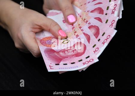 Chinesische Yuan-Banknoten in weiblichen Händen. Frau zählt Papiergeld Stockfoto