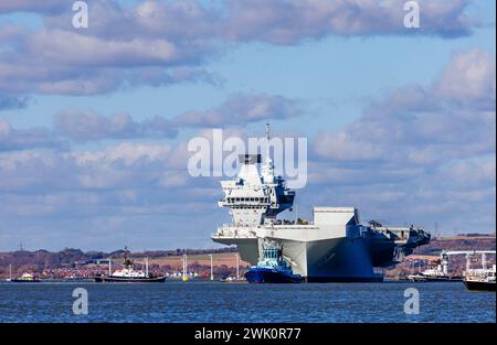 Schlepper „Phenix“ führt den Flugzeugträger der Queen Elizabeth-Klasse „HMS Prince of Wales“ aus Portsmouth Harbour, Portsmouth, Hampshire, Südküste Englands Stockfoto