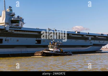 Schlepper 'SD Suzanne' eskortiert den Flugzeugträger 'HMS Prince of Wales', der Portsmouth Harbour, Portsmouth, Hampshire, an der Südküste Englands ablegt Stockfoto