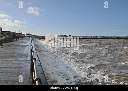 Die Wellen der Hochfrühlingsheime stürzen über die Promenade in Maryport, Cumbria, Großbritannien Stockfoto