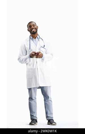 Der Doktor, in voller Höhe, auf weißem Hintergrund, spricht am Telefon Stockfoto