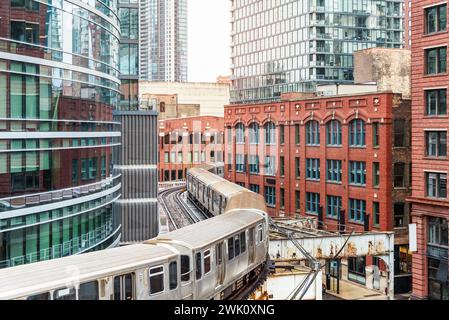 Eelvated Silver Train, der zwischen alten und modernen Gebäuden in der Innenstadt von Chicago verkehrt Stockfoto