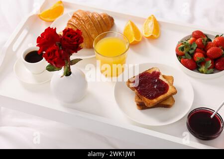 Tablett mit leckerem Frühstück auf dem Bett, Nahaufnahme Stockfoto