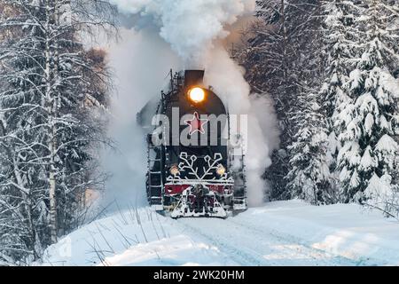 RUSKEALA, RUSSLAND - 20. JANUAR 2024: Sowjetische Dampflokomotive L-5031 (Lebedjanka) des Ruskeala Express-Zuges in einem verschneiten Wald an einem Januarmorgen. Stockfoto