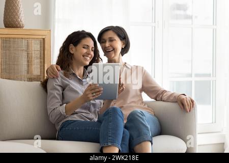 Mit einem modernen digitalen Tablet können Sie sich auf der Couch für eine Familie mit mehreren Generationen setzen Stockfoto