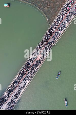 HANGZHOU, CHINA - 17. FEBRUAR 2024 - Kreuzfahrtschiffe fahren unter der kaputten Westseebrücke, die von Touristen stark besucht wird, in der Stadt Hangzhou, Zhe Stockfoto