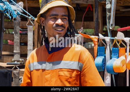 Porträt eines glücklichen afrikanischen Unternehmers, Straßenverkäufers, Verkaufstools und verschiedener Hardware Stockfoto