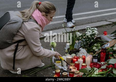 Berlin, Deutschland. Februar 2024. Nach dem Tod des russischen Oppositionsführers Alexej Nawalny zündet eine Frau Kerzen an einer provisorischen Gedenkstätte vor der russischen Botschaft in Berlin an. Quelle: SOPA Images Limited/Alamy Live News Stockfoto