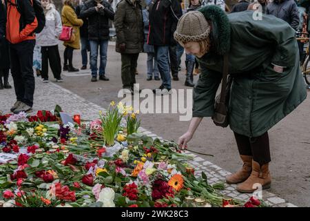Berlin, Deutschland. Februar 2024. Eine Frau platziert eine Blume an einer provisorischen Gedenkstätte vor der russischen Botschaft in Berlin nach dem Tod des russischen Oppositionsführers Alexej Nawalny. Quelle: SOPA Images Limited/Alamy Live News Stockfoto