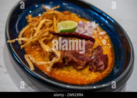 Khao Soi, thailändische Currynudelsuppe im nördlichen Stil mit Fleisch, serviert in einer Schüssel Stockfoto