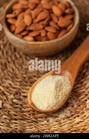 Frisches Mandelmehl in einem Holzlöffel und Mandeln. Glutenfreies Lebensmittelkonzept. Stockfoto