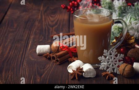Gemütliches Winterstilleben. Tasse heißer Kakao mit Marshmallows und Zimt auf rustikalem Holztisch. Heißgetränk und Gewürze. Festliche Einrichtung. Stockfoto