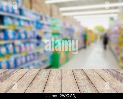 Holztischplatte mit Waschmittelregalen im Wäschereibereich im Supermarkt oder Lebensmittelgeschäft verschwommener Hintergrund Stockfoto