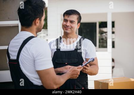 Verlegung von Servicemitarbeitern nach draußen Entladen von Kartons und Checkliste für die Umzugsfirma. Ihre Stockfoto