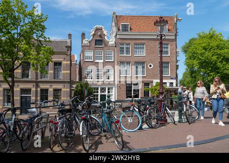 Man spaziert entlang der Grachtenhäuser an der Ecke Prinsengracht und Lauriergracht in Amsterdam. Stockfoto