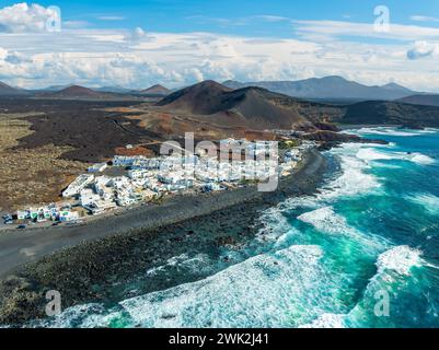 El Golfo: Ein malerisches Dorf, das den wilden Atlantik umschließt, vor der dramatischen Vulkanlandschaft Lanzarotes, eine eindrucksvolle Szene für jeden Zuschauer. Stockfoto