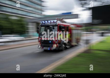 Feuerwehrauto auf einem Notruf, der mit hoher Geschwindigkeit im Stadtzentrum von Manchester unterwegs ist Stockfoto