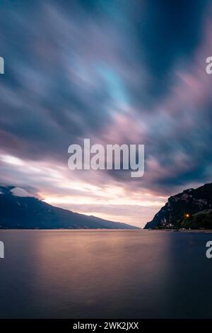 Wolken schweben über dem Gardasee im pastellfarbenen Licht der Morgendämmerung, Limone, Lombardei, Italien Stockfoto