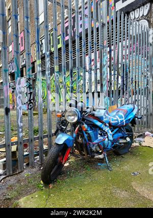 Verlassenes Motorrad, bedeckt mit Graffiti in Shoreditch, East London Stockfoto