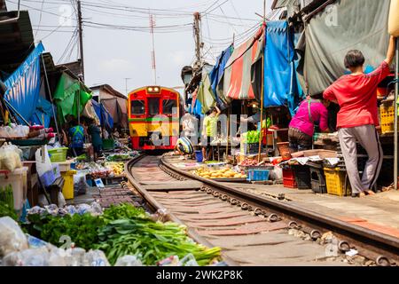 Rom Hoop Schirmmarkt. Thai Railway mit lokalem Zug fährt durch den Mae Klong Markt in der Samut Songkhram Provinz, Thailand. Touristenattraktion in tr Stockfoto