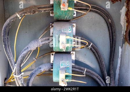 Nahaufnahme von schmutzigen schwarzen Kabeln von Schaltern und Schaltkreisen im Schaltkasten, System und elektrischen Verbindungen in einem offenen Schrank im öffentlichen Park in Mexiko Stockfoto