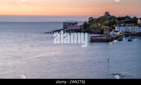 Tenby Hafen und Rettungsbootstation, bei Sonnenaufgang an einem ruhigen Sommertag. Stockfoto